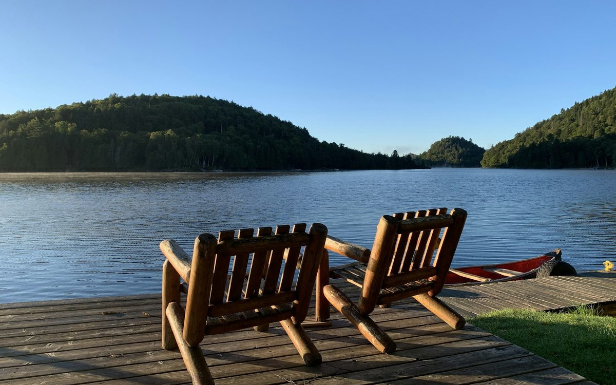 Lakefront deck with Adirondack chairs at a Pocono short-term rental