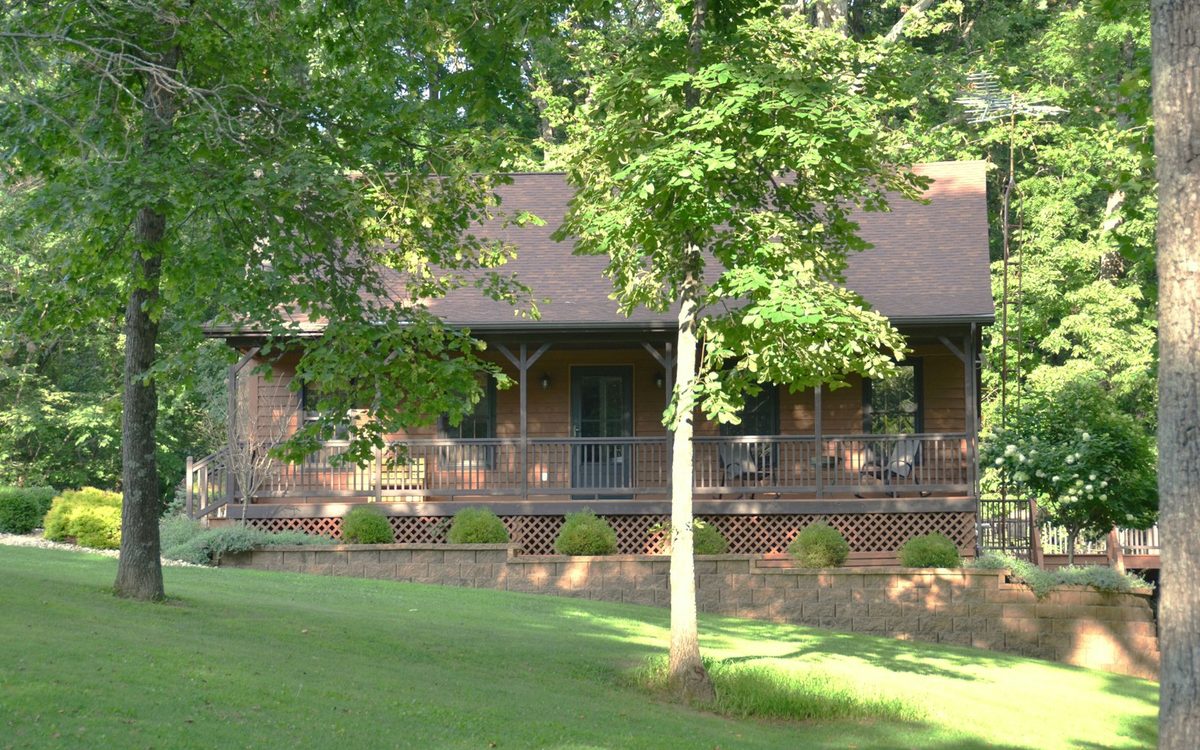 Log home with a covered porch on a wooded lot in the Pocono Mountains