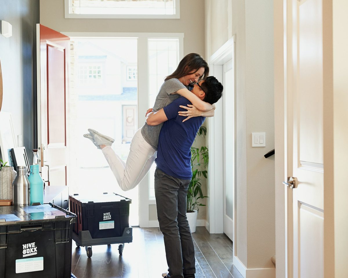 First-time homebuyers celebrating in the doorway of their new home
