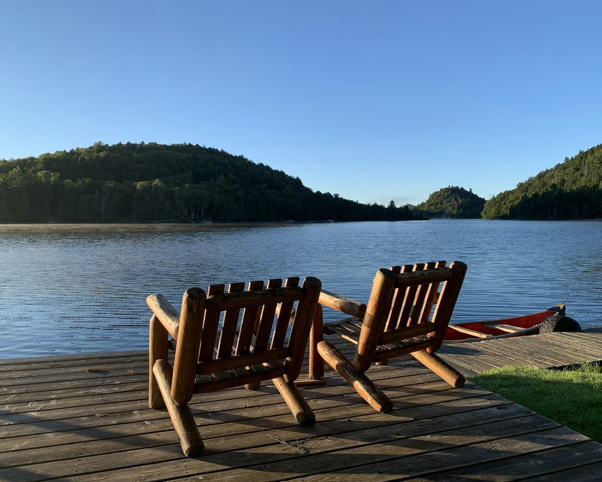 Lakefront deck with Adirondack chairs at a Pocono short-term rental