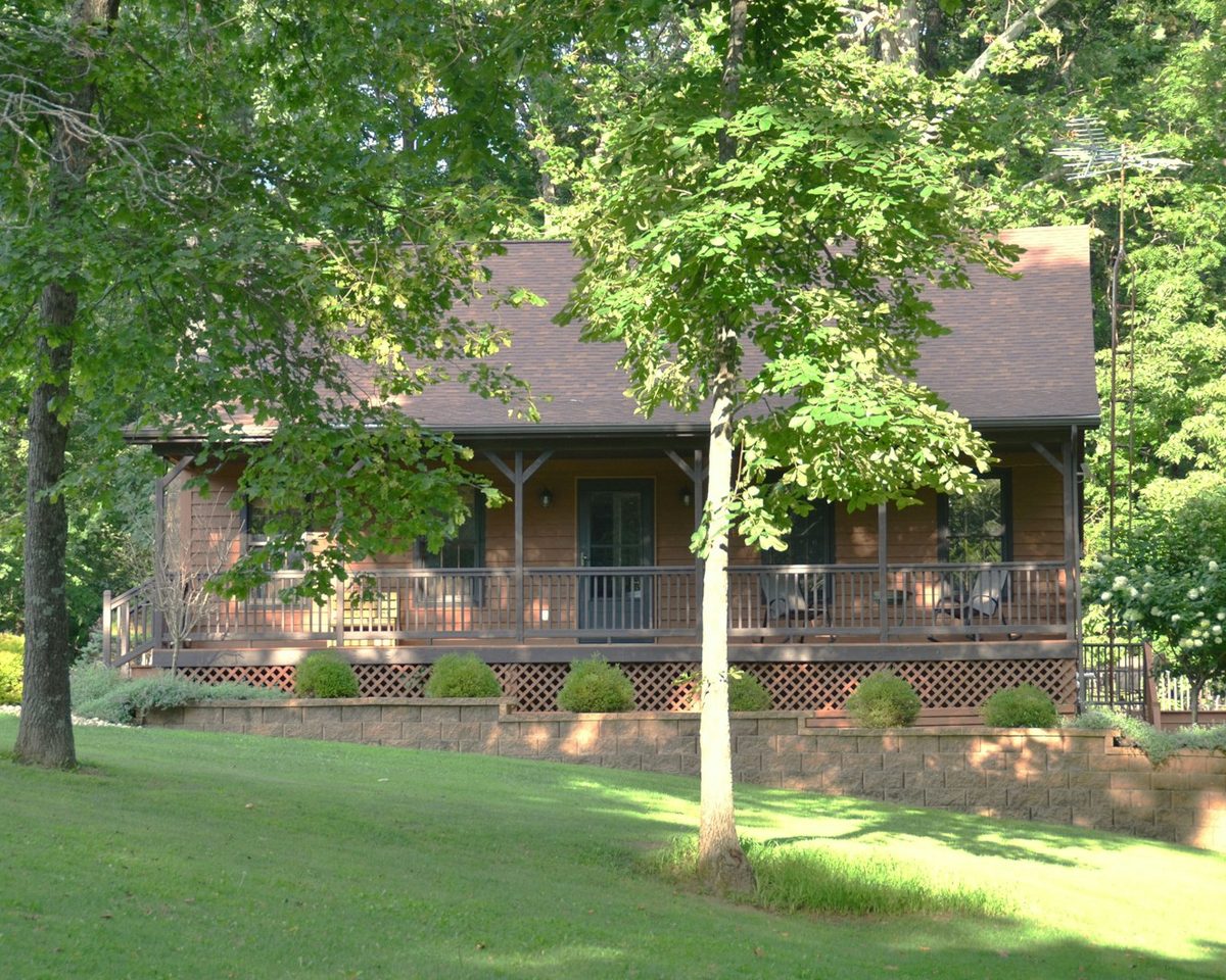 Log home with a covered porch on a wooded lot in the Pocono Mountains